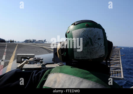 140313-N-EY632-049 mediterrane Meer (13. März 2014) - A Seemann an Bord des Flugzeugträgers USS George H.W. Bush (CVN-77) steht Sicherheit zusehen, wie ein F/A - 18 C Hornet, angeschlossen an die "Valions" des Strike Fighter Squadron (VFA) 15 bereitet sich auf das Flugdeck ausziehen. George H. W. Bush ist auf eine geplante Bereitstellung unterstützen maritimer Sicherheitsoperationen und Sicherheitsbemühungen Zusammenarbeit Theater in den USA 6. Flotte Einsatzgebiet. (Foto: U.S. Navy Mass Communication Specialist 2. Klasse Joshua K. Horton/freigegeben)  Nehmen Sie das Gespräch auf Twitter (https://twitter.com/naveur n Stockfoto