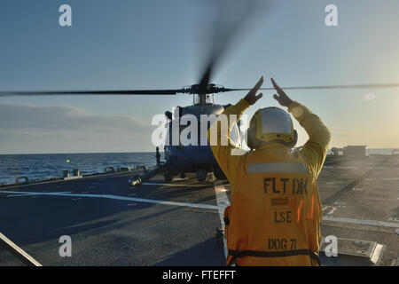 Dieses Bild zeigt Boatswains Mate 2nd Class Billie Johnson, der während des Flugs an Bord der USS Ross (DDG 71) im Mittelmeer einen Hubschrauber der US Air Force signalisiert. Die USS Ross, ein Lenkraketenzerstörer der Arleigh-Burke-Klasse, unterstützt US-Marineoperationen in Europa. Stockfoto