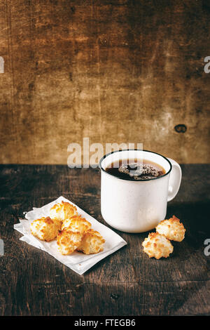 Große Vintage Tasse Tee mit winzigen Coconut Cookies auf rustikalen Holztisch. Selektiven Fokus. Stockfoto