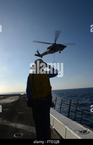 Mittelmeer (3. Oktober 2014)--Luftfahrt Boatswain Mate (Handling) 3. Klasse Kimberly Toro, von Galveston, Texas, grüßt ein UH-1 Huey auf dem Flugdeck der amphibischen Dock Transportschiff USS Mesa Verde (LPD 19) während einer vertikalen Nachschub auf See mit Military Sealift Command Flotte Nachschub Öler USNS Leroy Grumman (T-AO-195). Mesa Verde, Teil der Bataan amphibische bereit Gruppe mit eingeschifften 22. Marine Expeditionary Unit führt Marinebetriebe in den USA 6. Flotte Bereich der Maßnahmen zur Erhöhung der Sicherheit der Vereinigten Staaten Interessen in der Eu Stockfoto