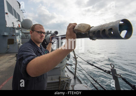 Schwarzes Meer (15. Oktober 2014) – des Kanoniers Mate Seemann James Lumbley führt periodische Wartungsarbeiten auf der Backbordseite Mark 38 MOD 2 25 mm Maschinengewehr an Bord der Arleigh-Burke-Klasse geführte Flugkörper Zerstörer USS Cole (DDG-67). Cole, in Norfolk, Virginia, Gridley führt Marinebetriebe in den USA 6. Flotte Bereich der Maßnahmen zur Erhöhung der Sicherheit der Vereinigten Staaten in Europa interessiert. Stockfoto