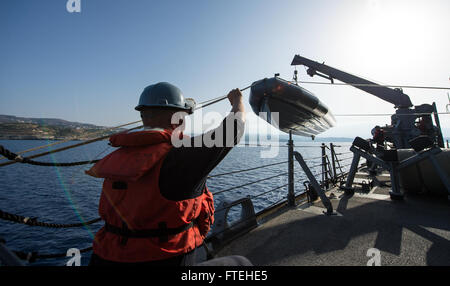 Mittelmeer (15. Oktober 2014) Boatswain Mate 1. Klasse Jason Harrison signalisiert der Bootsmann Mate 2. Klasse John Acheson bei gleichzeitiger Erhöhung ein Festrumpf-Schlauchboot an Bord der Arleigh-Burke-Klasse geführte Flugkörper Zerstörer USS Mitscher (DDG-57). Mitscher, in Norfolk, Virginia, Gridley führt Marinebetriebe in den USA 6. Flotte Bereich der Maßnahmen zur Erhöhung der Sicherheit der Vereinigten Staaten in Europa interessiert. Stockfoto