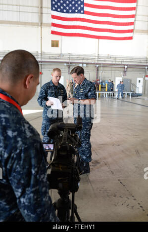 SIGONELLA, Sizilien (29. Oktober 2014) Admiral Mark Ferguson, Kommandeur der US Naval Forces Europe-Africa, spricht mit Mass Communication Specialist 2. Klasse Ryan McLearnon während eines Interviews mit American Forces Network (AFN) Sigonella nach einem All-Hands-Anruf an Bord Naval Air Station (NAS) Sigonella, Okt. 29.  Ferguson dankte Segler für ihre Beiträge für die NATO und US Naval Forces Europe-Africa Mission. Stockfoto