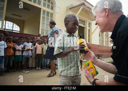 SÃO TOMÉ, São Tomé und Príncipe (16. August 2013) Secretary Of The Navy (SECNAV) Ray Mabus gibt einem Schüler an der Escola Dona Maria Jesus-Schule in São Tomé, São Tomé und Príncipe eine Schachtel Buntstifte, während spenden Schulsachen. São Tomé und Príncipe ist einer von mehreren Ländern in der gesamten Region wo Mabus Matrosen und Marinesoldaten stößt, zivile und militärische Beamte, Sicherheit und Stabilität zu diskutieren und bestehende Partnerschaften mit afrikanischen Nationen zu verstärken. Stockfoto