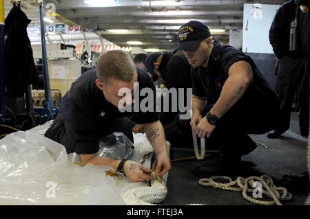 Mittelmeer (1. November 2014) Boatswain Mate Seemann Joe Etter, rechts von Chesapeake, Virginia, und Bootsmann der 3. Klasse Alexander Ames, aus Emett, Idaho, Spleiß Paaren eine Befestigungsleine an Bord des Flugzeugträgers USS George H.W. Bush (CVN-77). George H.W. Bush, in Norfolk, Virginia, Gridley führt Marinebetriebe in den USA 6. Flotte Bereich der Maßnahmen zur Erhöhung der Sicherheit der Vereinigten Staaten in Europa interessiert. Stockfoto