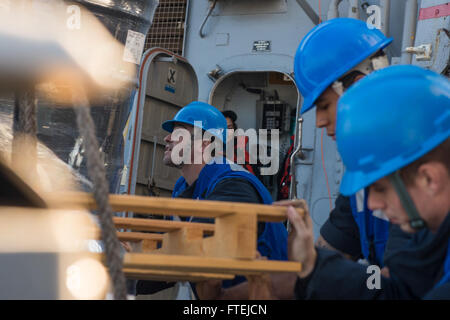 Mittelmeer (23. November 2014) – der Bootsmann Mate 2. Klasse Douglas Thomas, ursprünglich aus Los Angeles, führt eine Palette von Geschäften wie es auf dem Deck während einer Evolution Nachschub auf See an Bord der USS Cole (DDG-67) 23. November 2014 gesenkt wird. Cole, ein Zerstörer der Arleigh-Burke-Klasse-geführte Flugkörper in Norfolk, Gridley führt Marinebetriebe in den USA 6. Flotte Bereich der Maßnahmen zur Erhöhung der Sicherheit der Vereinigten Staaten in Europa interessiert. Stockfoto