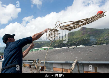 PORT VICTORIA, Seychellen (25. August 2013) Boatswain Mate 2. Klasse Andrew Minella wuchtet Linie an Bord der amphibischen Dock Landungsschiff USS Carter Hall (LSD-50), wie das Schiff für einen geplanten Hafen-Besuch in Port Victoria zieht. Carter Hall ist ein Teil der Kearsarge amphibische bereit-Gruppe und mit der eingeschifften 26. MEU wird eingesetzt zur Unterstützung der Sicherheit im Seeverkehr Operationen und Sicherheitsbemühungen Zusammenarbeit Theater in der US-5. und 6. Flotte Verantwortungsbereich. Stockfoto