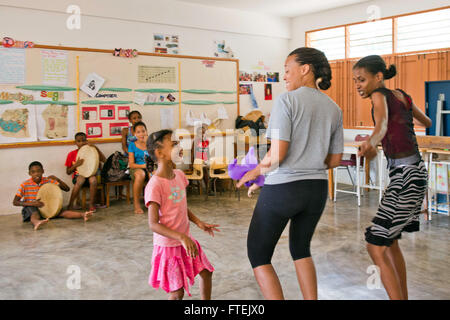 PORT VICTORIA, Seychellen (26. August 2013) Chief (Select) Yeoman Chere Wilson (Mitte), zugewiesen USS Carter Hall (LSD-50), Tänze mit Einheimischen, wie sie bei ehrenamtlichen Projekt am Beau Vallon Schule Musizieren. Carter Hall ist ein Teil der Kearsarge amphibische bereit-Gruppe und mit der eingeschifften 26. MEU wird eingesetzt zur Unterstützung der Sicherheit im Seeverkehr Operationen und Sicherheitsbemühungen Zusammenarbeit Theater in der US-5. und 6. Flotte Verantwortungsbereich. Stockfoto