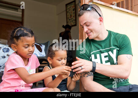 PORT VICTORIA, Seychellen (26. August 2013) Lance Cpl. Daniel Rodriguez zugewiesen, 26. Marine Expeditionary Unit (MEU) zeigt Kinder vor Ort Fotos während der ehrenamtlichen Projekt am Beau Vallon Schule. Carter Hall ist ein Teil der Kearsarge amphibische bereit-Gruppe und mit der eingeschifften 26. MEU wird eingesetzt zur Unterstützung der Sicherheit im Seeverkehr Operationen und Sicherheitsbemühungen Zusammenarbeit Theater in der US-5. und 6. Flotte Verantwortungsbereich. Stockfoto