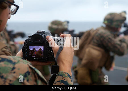 Mittelmeer (4. Januar 2015) Lance Cpl. Dani A. Zunun, einen Kampf Kameramann zugewiesen 24. Marine Expeditionary Unit, fängt Videobilder während einer live-Feuer-Übung auf dem Flugdeck an Bord der USS Iwo Jima 4. Januar 2015. Durchführung der 24. MEU und Iwo Jima amphibisches bereit Gruppe Marinebetriebe in den USA 6. Flotte Bereich der Maßnahmen zur Erhöhung der Sicherheit der Vereinigten Staaten in Europa interessiert. Stockfoto