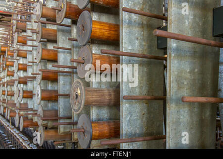 Hölzerne Klöppel hängen Pflöcke in antiken Geräte wiederum der Jahrhundert Seide Fabrik zu werfen. Stockfoto