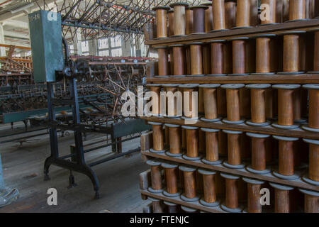 Rack mit hölzernen Spulen mit antiken Ausstattung Erdgeschoss der Wende des Jahrhunderts Seide Fabrik zu werfen. Stockfoto