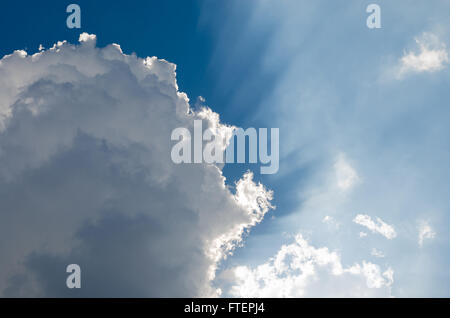 Sonne durch die Wolken am blauen Himmel scheint. Stockfoto