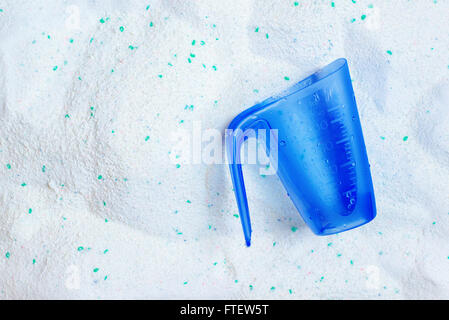 Waschen von Wäsche Waschpulver und blauem Kunststoff Messbecher, Ansicht von oben Stockfoto