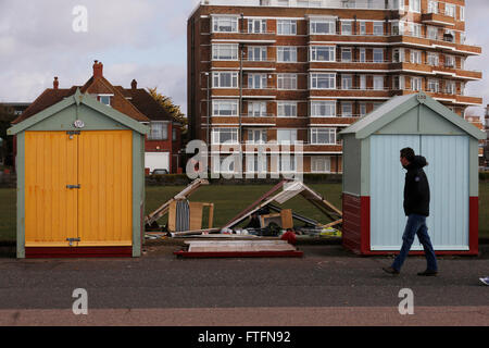 Brighton, UK. 28. März 2016. Ein Passant sieht beschädigte Strandhütten in Hove nach Wind und Regen durch Sturm Katie brachte die Küste in Brighton, East Sussex, UK Montag, 28. März 2016 zerschlagen. BBC berichten "Sturm Katie Böen von bis zu 105 km/h Misshandlung von England und Wales, mit mehreren Flügen von Flughäfen umgeleitet gesehen hat und große Brücken geschlossen". Bildnachweis: Luke MacGregor/Alamy Live-Nachrichten Stockfoto