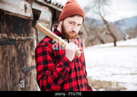 Porträt von schöner bärtigen Mann mit Axt im Dorf Stockfoto