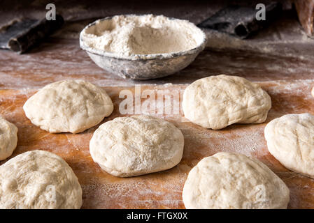 Stillleben mit einzelnen Raw Brot ruht auf rustikalen Holz Mehl hautnah Stockfoto