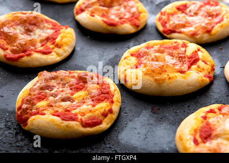 Stillleben mit frisch gebackenen Pizza Brötchen bedeckt in Tomatensauce und Käse überbacken Kühlung an heißen Pfanne frisch aus dem Ofen ich hautnah Stockfoto