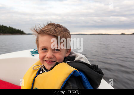 Junge Junge das Tragen einer Schwimmweste an der Vorderseite von einem Motorboot am Meer bei camera Model Release: Ja. Property Release: Nein. Stockfoto