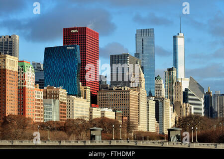 Ein Teil der Skyline von Chicago ist unter einigen niedrig hängenden Wolken über dem Grant Park in der Innenstadt von Chicago, Illinois, USA beleuchtet. Stockfoto