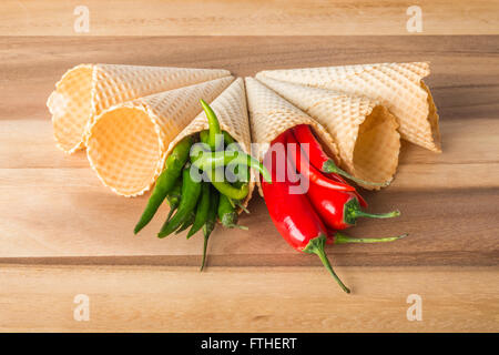 Rot und grün hot Chili Peppers in Wafer Kegel auf hölzernen Hintergrund Stockfoto