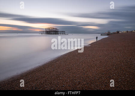 Mann auf dem Kies in West Hove, East Sussex Stockfoto