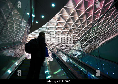 Mann geht auf der Rolltreppe in Kings Cross Railway Station, London, UK Stockfoto