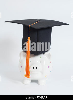 Sparschwein mit schwarzer Graduierung Hut auf weißem Hintergrund Stockfoto