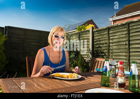 Frau, Essen im Freien zu Hause Stockfoto