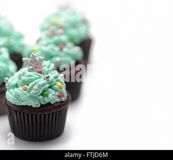 Weihnachten-Cupcakes mit traditionellen Dekorationen auf weißem Hintergrund Stockfoto