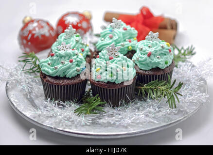 Weihnachten-Cupcakes mit traditionellen Dekorationen auf einer Platte Stockfoto