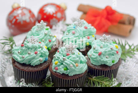 Weihnachten-Cupcakes mit traditionellen Dekorationen auf einem Tisch Stockfoto