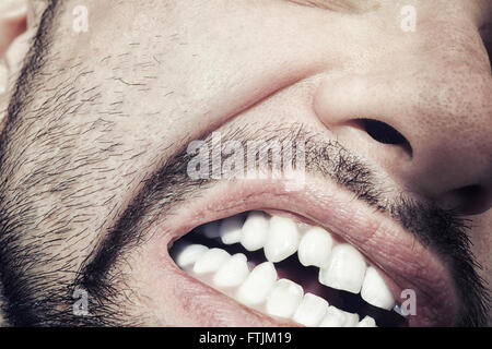 Männliche Mund mit fletschenden Zähnen Nahaufnahme Stockfoto