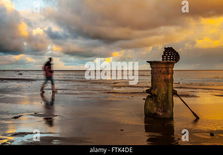 Southport, Merseyside, UK. Am 30. März 2016. UK Wetter. Dramatischer Sonnenaufgang über der Irischen See Ausleuchten der 'Liverpool Fleetwood viktorianische gusseiserne Gezeiten Standard bei niedrigem Wasserstand. Die römischen Ziffern empfehlen es für ein Schiff Entwurf Markierungen in vergangenen Zeiten Kennzeichnung einen Kanal für den Zugang zu den inzwischen aufgelösten bezieht, und versandete der Hafen. Stockfoto