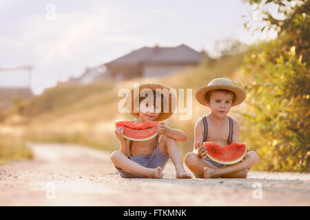 Zwei süße kleine Jungs, Essen Wassermelone auf einem ländlichen Dorf im Sommer Stockfoto