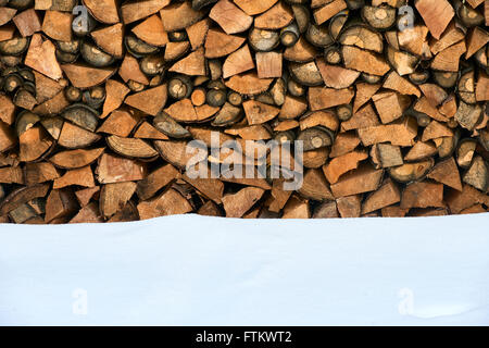 Brennholz gestapelt im Winter. Holz-Haufen mit Schnee für Brennholz gestapelt Stockfoto