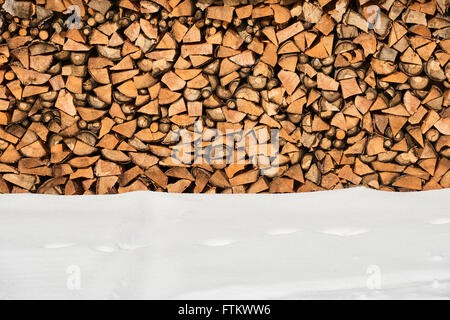 Brennholz gestapelt im Winter. Holz-Haufen mit Schnee für Brennholz gestapelt Stockfoto