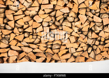 Brennholz gestapelt im Winter. Holz-Haufen mit Schnee für Brennholz gestapelt Stockfoto
