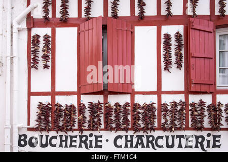 Espelette Pfeffer Saiten hängen an der Fassade eine Metzgerei in Espelette, Frankreich Stockfoto
