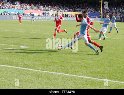 New York, NY USA - 26. März 2016: David Villa (7) von New York City FC kämpft für Ball mit London Woodberry (28) von New England Revolution im Yankee Stadium Stockfoto