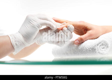 Entfernung von Nagellack. Maniküre. Kosmetikerin entfernt Nagellack mit einem in Aceton getränkten Wattebausch. Stockfoto