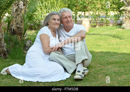 Ältere Paare sitzen auf Gras Stockfoto