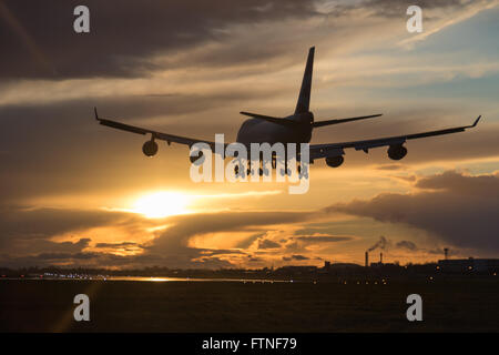 Eine British Airways Boeing 747-400 landet am Flughafen London Heathrow als der Sonnenuntergang beleuchtet die Wolken Stockfoto