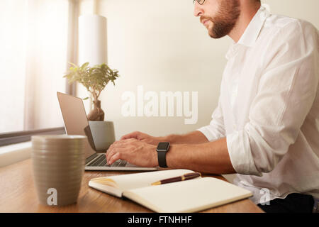 Bild der Geschäftsmann auf Laptop zugeschnitten. Mann, der vom home-Office arbeitet. Stockfoto