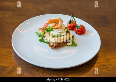 Sandwich mit pochiertem Ei, Parmaschinken und Tomaten Stockfoto