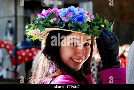 New York City: Lächelnde junge Frau mit einer bunten Blume Haube bei der jährlichen Easter Parade auf der Fifth Avenue Stockfoto