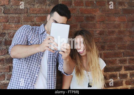 Junge schöne Paar nehmen Selfie mit einem Tablet auf der Straße. Technologie-Konzept Stockfoto