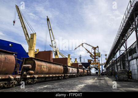 Trainieren Sie, neben Frachter im Hafen geladen wird Stockfoto