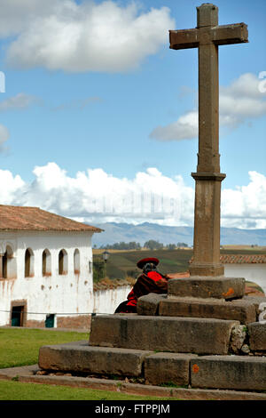 Quechua-Frau sitzt unter Kreuz, Chinchero, Cusco, Peru Stockfoto