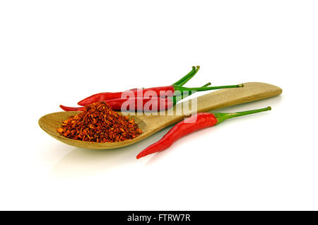 Rote Paprika-Chili (Capsicum Frutescens L.) mit einem Löffel Cayenne Pfeffer auf weißem Hintergrund. Stockfoto